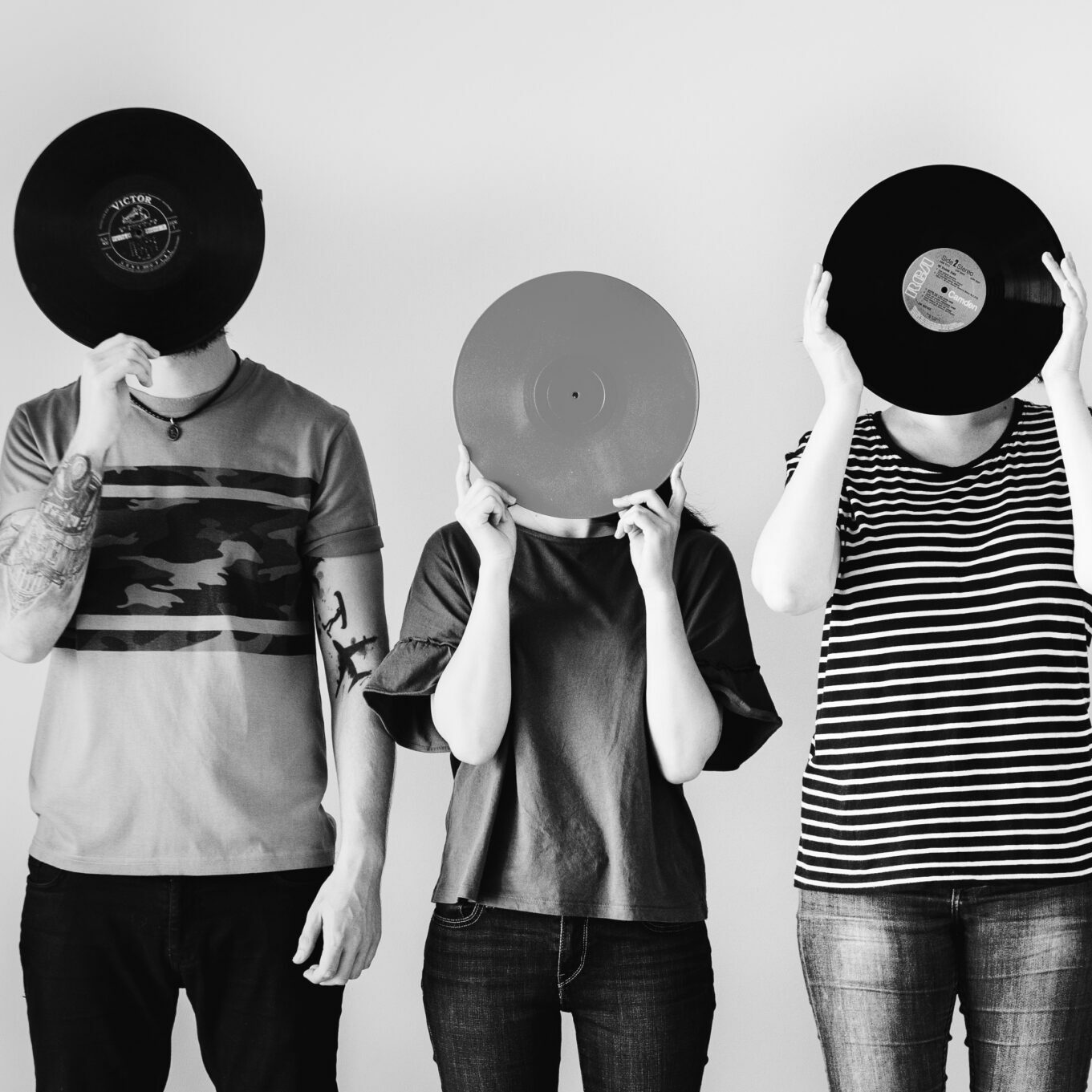 Young friends covering their faces with vinyls